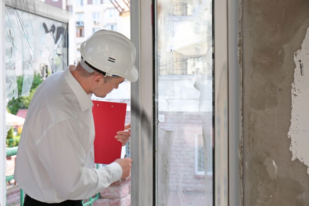 an inspector in a white safety hat inspecting defect building