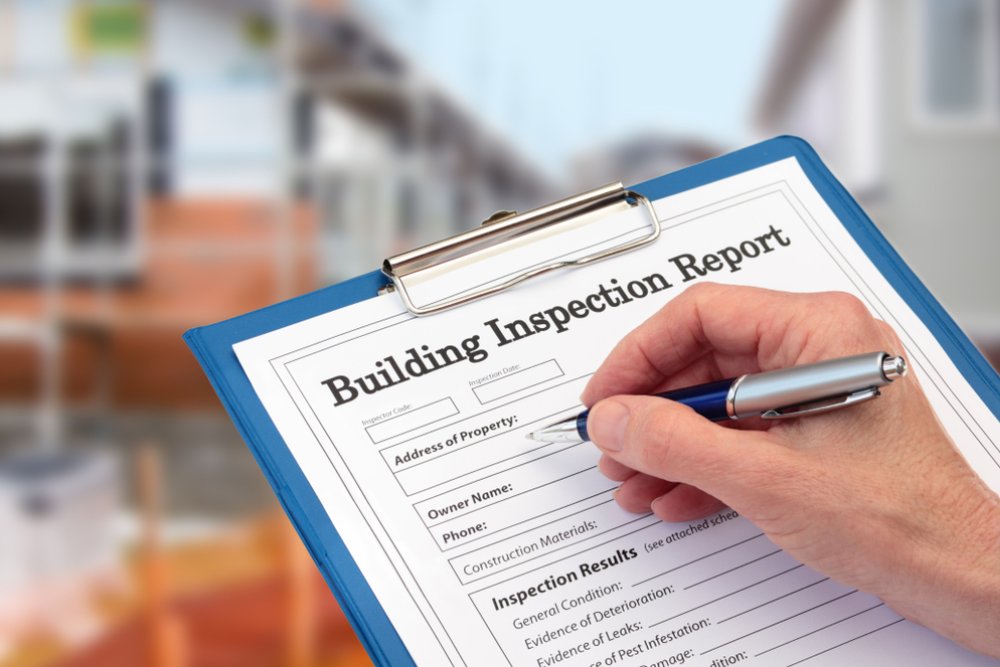 Building Inspector completing an inspection form on clipboard