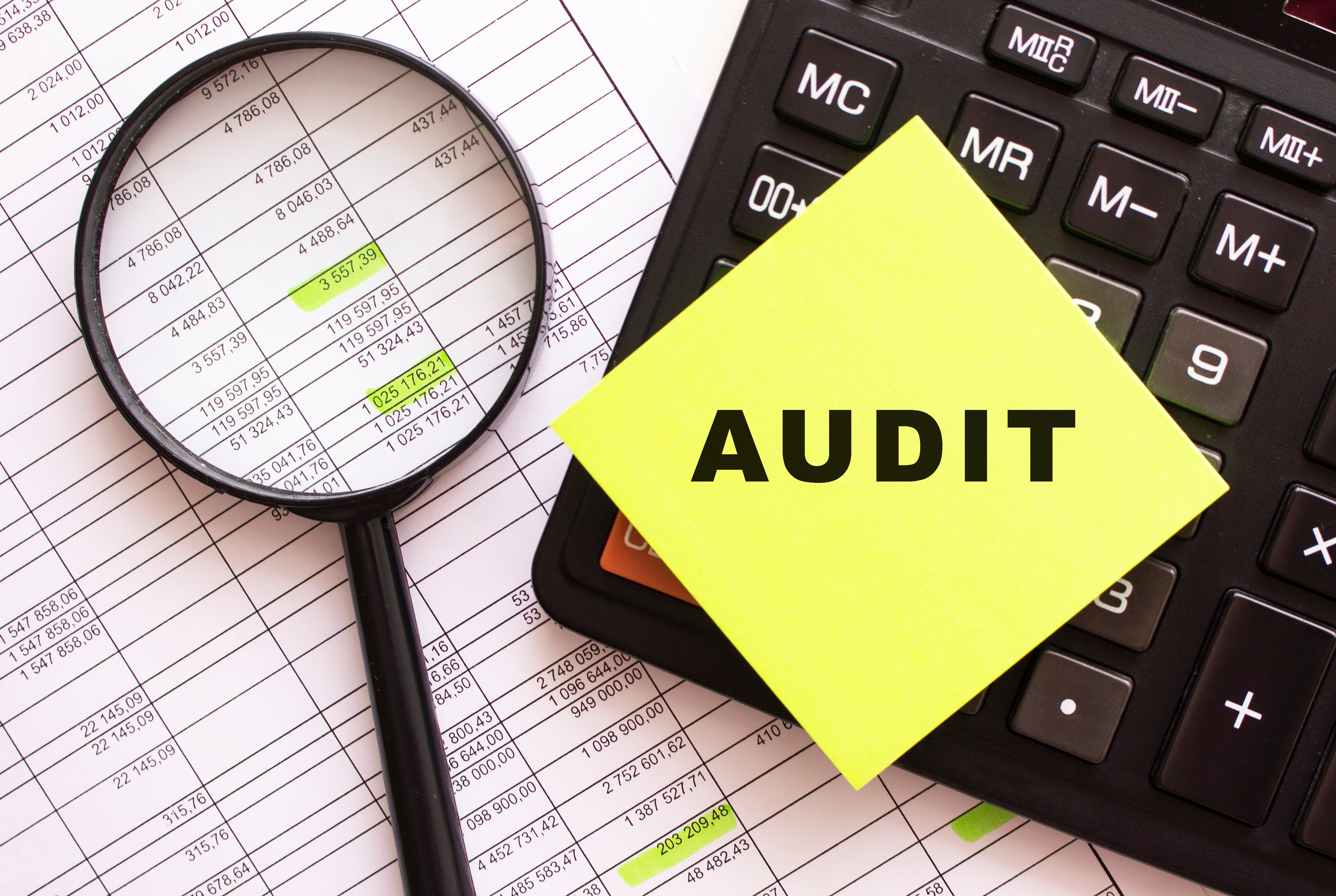 Body Corporate Audit Services with papers, calculator and magnifying glass